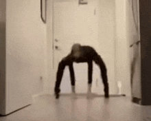 a blurry picture of a person doing a handstand on a floor in a hallway .