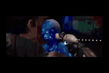 a man is standing next to a robot with a blue head .