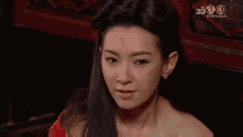 a woman is making a funny face in front of a tv screen .