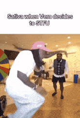 a man in a pink hat is dancing in a room with the words sativa when vern decides to stfu above him