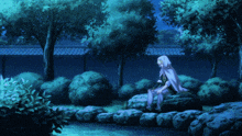 a person in a white cape sits on a rock near a pond
