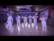 a group of young women are dancing in a dark room