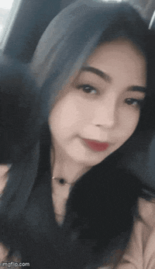 a woman is taking a selfie in a car .