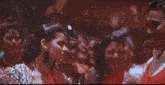a group of people are dancing together in a dark room and laughing .