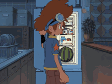 a boy in a blue shirt with a star on it stands in front of a refrigerator