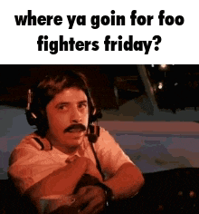 a man wearing headphones and a mustache is sitting in a plane .
