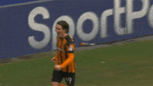 a soccer player stands in front of a sign that says ' presso '
