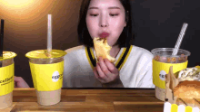 a woman is eating a piece of food next to a cup that says eggcellent on it