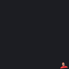 a man in a red shirt is sitting in front of a black background
