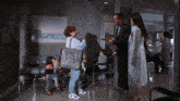 a group of people standing in a waiting room with a picture on the wall that says cp