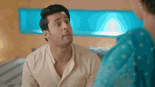 a man with a bandage on his head talks to a woman in a blue dress