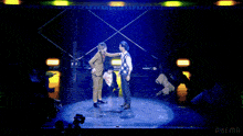 two men standing on a stage in front of a large screen that says abema
