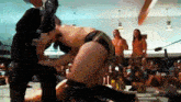 a man in a mask is wrestling another man in a wrestling ring .