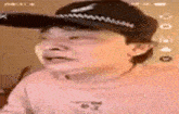 a close up of a man wearing a hat and a pink shirt .