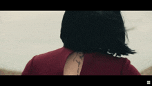 a woman in a red dress has a tattoo on her back that reads " i love you "