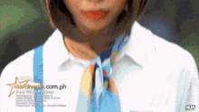 a woman in a white shirt and blue tie is standing in front of a starcinema.com.ph ad