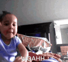 a little girl is sitting on a bed with the word woahh written on the bottom