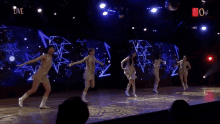 a group of women are dancing on a stage with the words live on the bottom