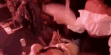 a group of people are dancing in a club while a woman is laying on the floor .