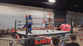 a wrestling ring with an emergency exit sign behind it