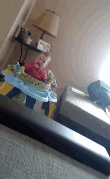 a baby is sitting in a baby walker on a couch