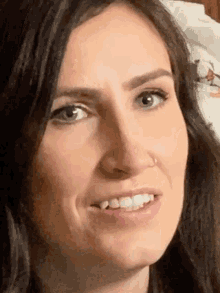 a woman with a nose ring is smiling and making a funny face