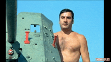 a shirtless man stands in front of a military vehicle with the words thinkiules below him