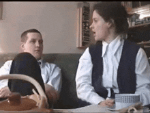 a man and a woman are sitting at a table talking to each other