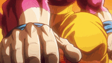 a close up of a person 's fist with a yellow shirt on
