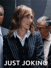 a woman in a striped suit is standing in front of a group of people .