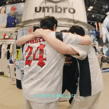 a group of people hugging in front of an umbro store