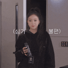 a girl in a black hoodie is holding a camera and has a name tag that says ' nct '