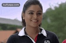 a close up of a woman wearing a black and white polo shirt smiling .