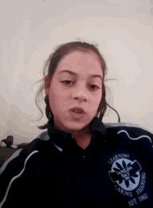 a girl wearing a jacket that says learning caring sharing on it