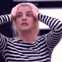 a woman in a striped shirt has her hands on her head and the word furby is above her
