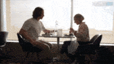 a man and a woman sit at a table in front of a window with the words downie live behind them