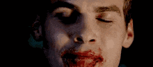 a close up of a vampire with blood on his face .