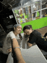 two people sitting at a table with one wearing a shirt that says ' sd '