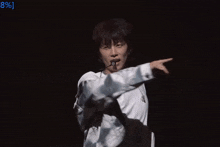 a man wearing a white shirt and a silver jacket is pointing