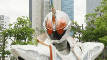a white and orange robot is standing in front of a city