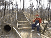 a man dressed as mario sits on a set of stairs in the woods
