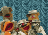 a group of muppets standing in front of a blue curtain with their mouths open