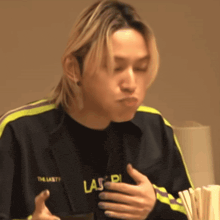 a young man wearing a black jacket with the word las on it