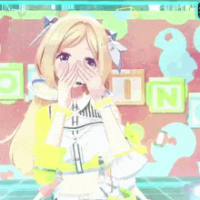 a blonde anime girl with a microphone on her head is standing in front of a wall with blocks on it .