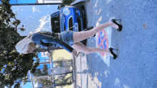 a woman in high heels stands in front of a blue mini cooper