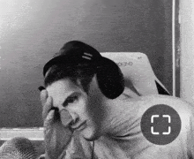 a black and white photo of a man wearing headphones and a circle with the letter c on it