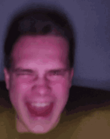 a blurry picture of a man 's face with a purple background