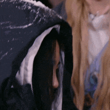 a woman in a black jacket with a white stripe on the hood