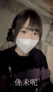 a girl wearing a mask with chinese writing on the bottom right