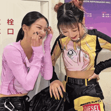 two girls are standing next to each other and one has a diesel belt